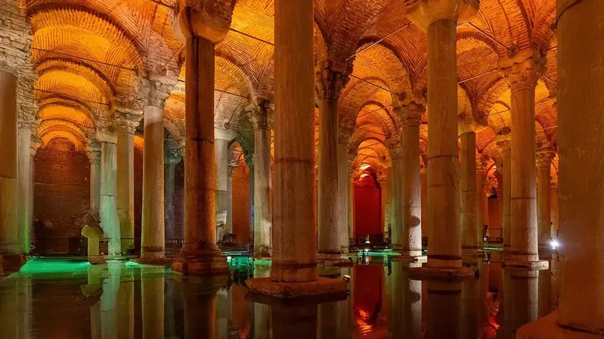 Reihen beleuchteter Säulen, gespiegelt im stillen Wasser der Basilika-Zisterne